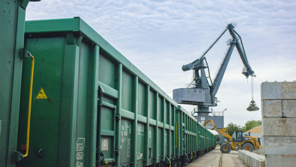 Umschlag von Erden mittels Radlader und Hafenkran in grüne Eisenbahnwaggons im bayernhafen Aschaffenburg