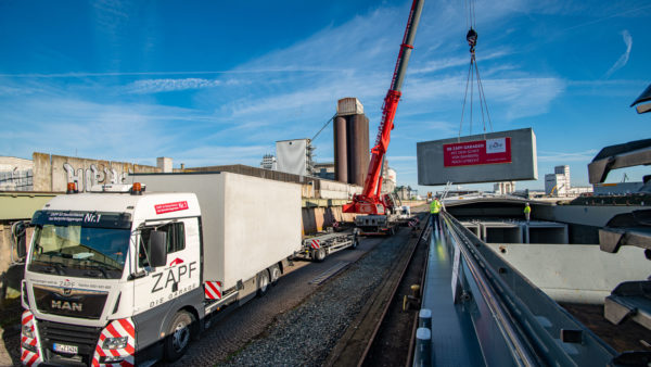 Verladung von Beton-Fertiggaragen vom LKW aufs Binnenschiff im bayernhafen Bamberg