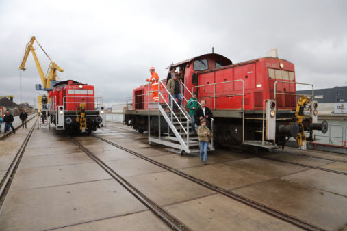 Besucher stehen an einer roten Lokomotive an