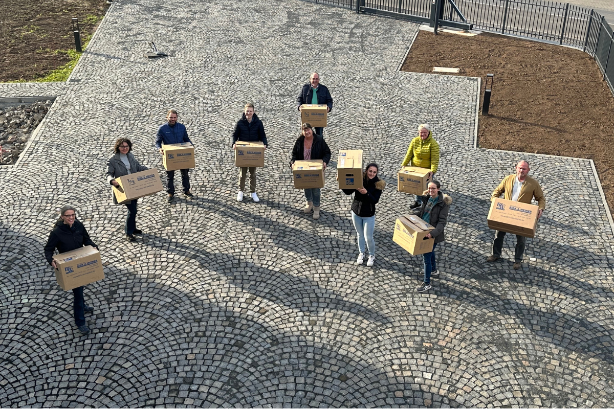 Gruppenbild mit Umzugskartons in den Händen von oben