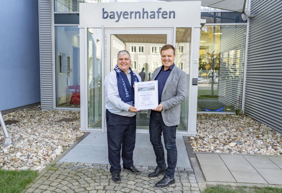 Bundestagsabgeordneter Stefan Schmidt erhält von bayernhafen-Geschäftsführer Joachim Zimmermann eine Urkunde überreicht